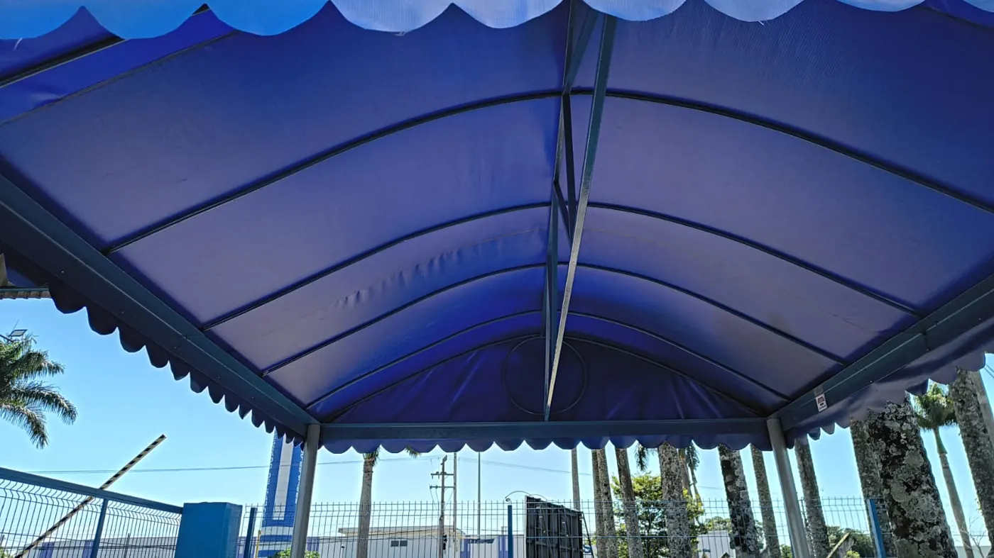 Toldo em arco em lona azul, obra da Tecno Toldos e Lonas